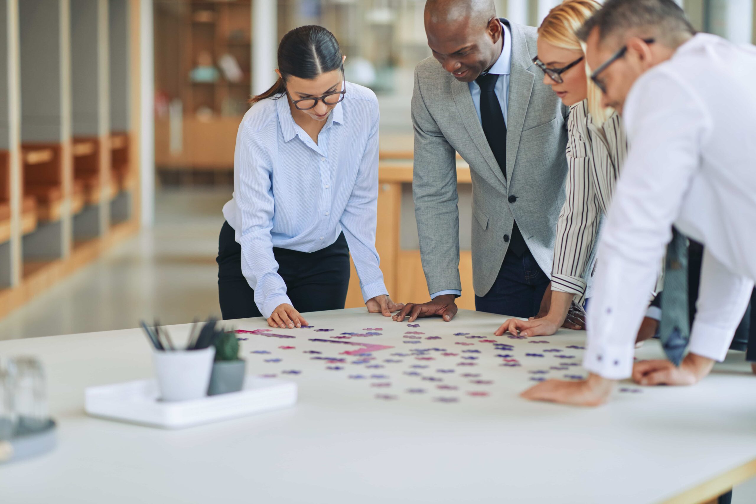 Diverse businesspeople solving a jigsaw puzzle tog